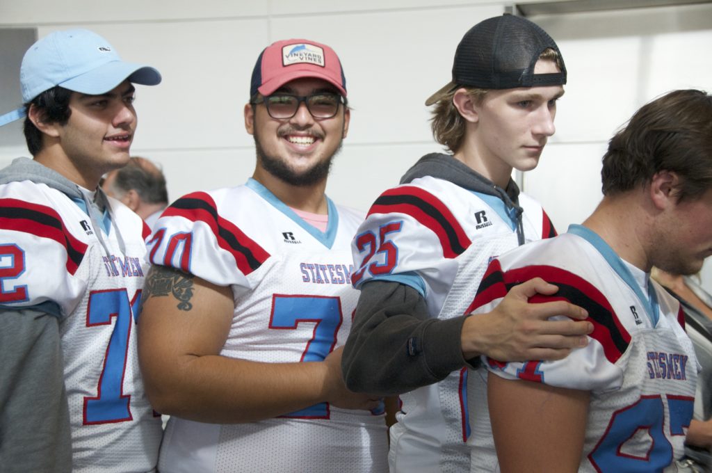 Marshall High School Football players greeting veterans